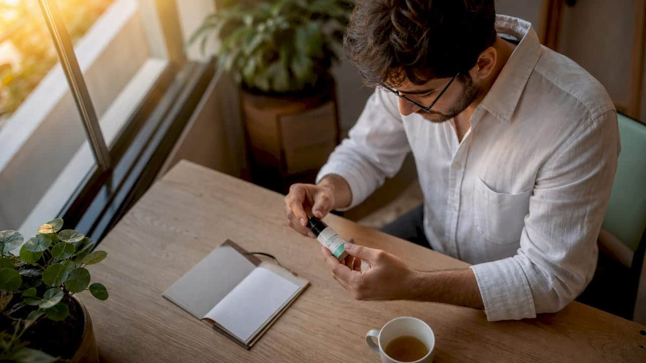 A specialist checks the labeling of a CBD product in his office.