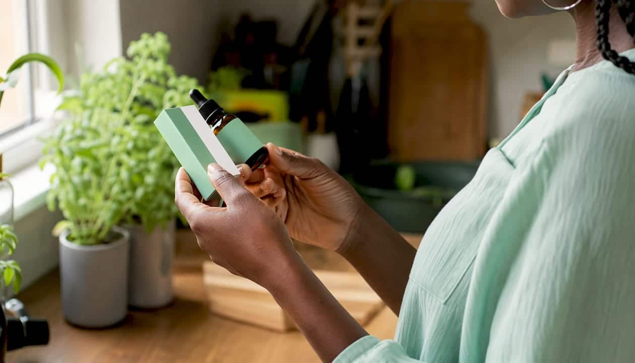 A woman carefully examines the label of a CBD product before buying it.